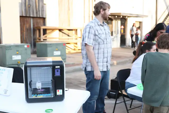 A 3D printer at work on a table on the street