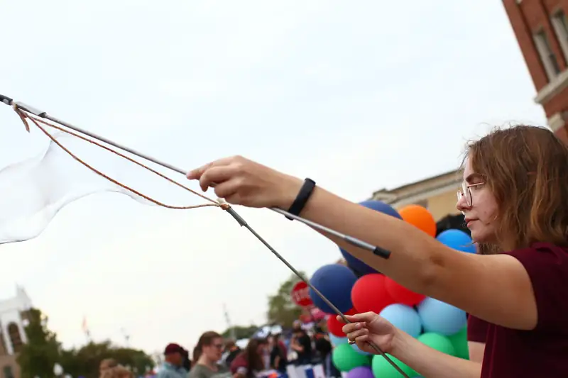 A visitor pulls a giant bubble wand on the street