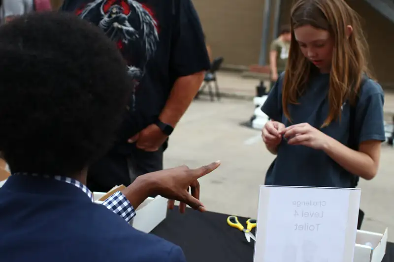 A mentor points a visitor to the next challenge
