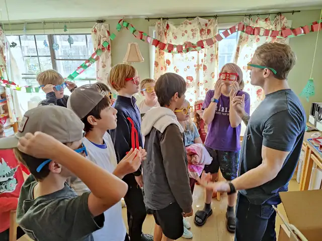 Students try on colorful glasses in a classroom