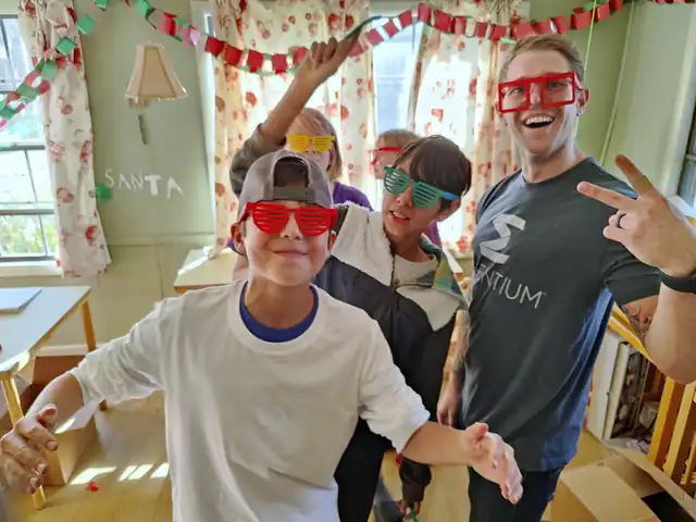Students in colorful glasses cheer in a classroom