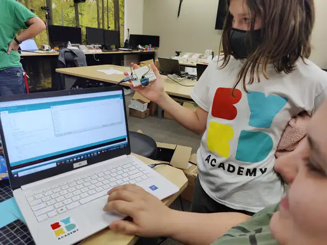 A student writes code on a laptop