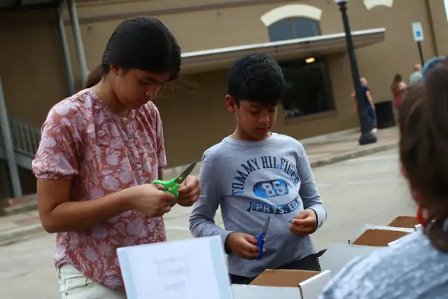 Two children cut and build at the challenge table