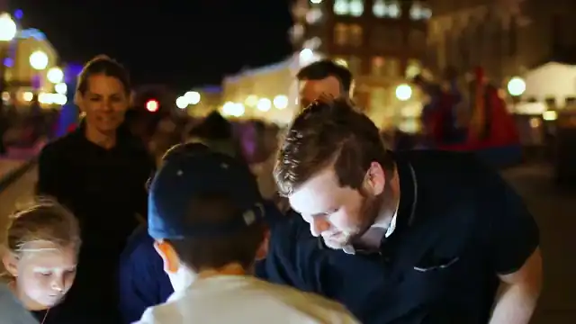 A grown-up leans in to build at the table after dark