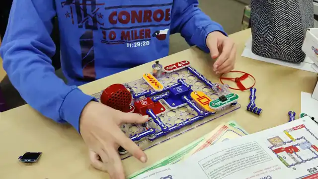 Hands snap a circuit together