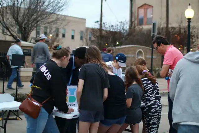 A crowd gathers around the Byrd Zone tables on the street
