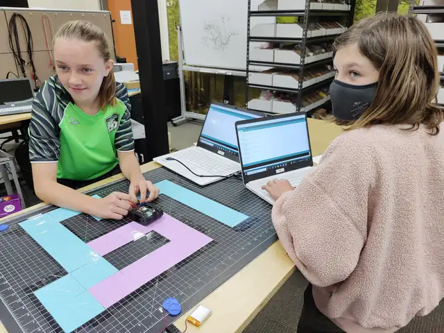 Students grin as their robot runs the maze