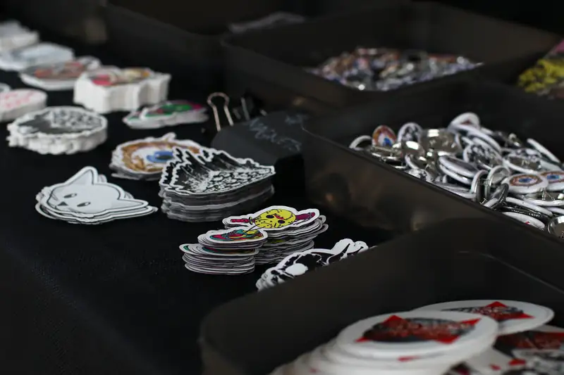 Stickers and keychains laid out on a table